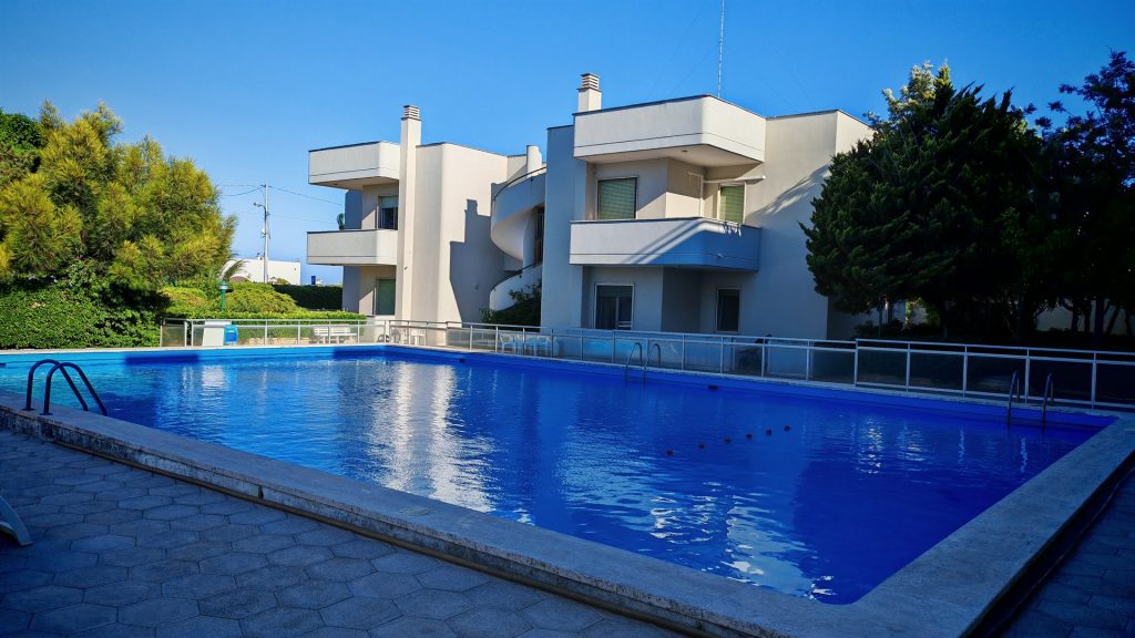 Piscina della casa vacanze con la palazzina sullo sfondo — La Casa di Franco, Torre dell'Orso