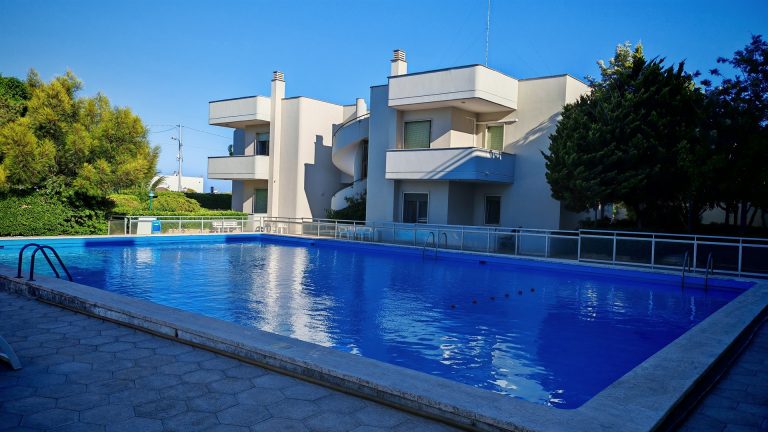 Piscina della casa vacanze con la palazzina sullo sfondo — La Casa di Franco, Torre dell'Orso