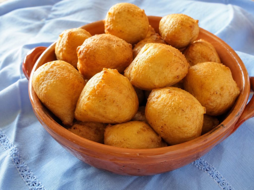Ciotola di terracotta piena di pittule salentine dorate e fritte