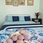 Camera matrimoniale con testata e quadri — La Casa di Franco, Torre dell'Orso