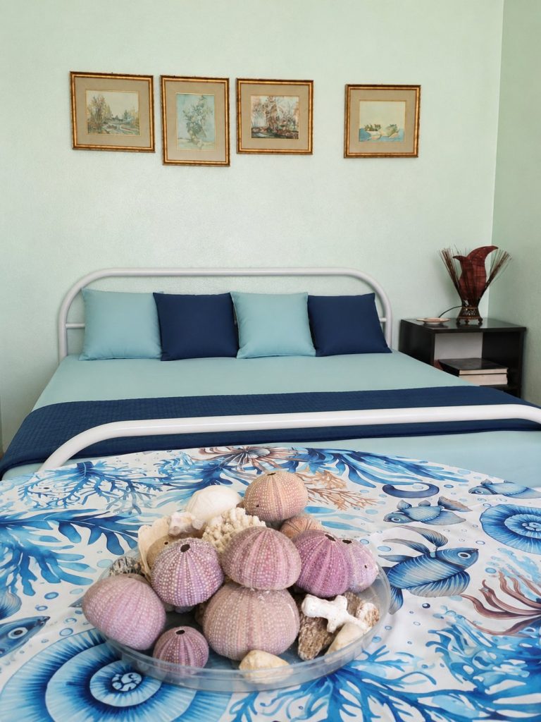 Camera matrimoniale con testata e quadri — La Casa di Franco, Torre dell'Orso
