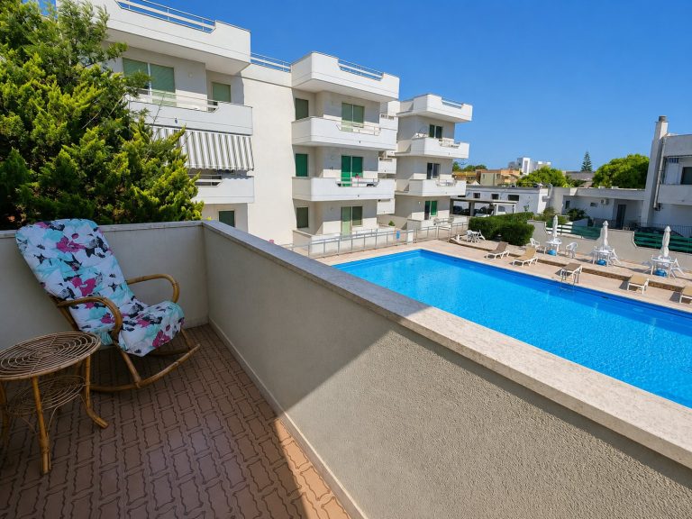 Veranda con lettino affacciata sulla piscina — La Casa di Franco, Torre dell'Orso