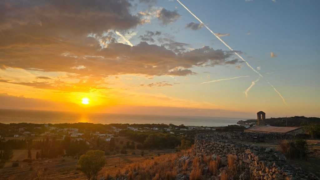 Tramonto sul mare del Salento da una collina con muretti a secco